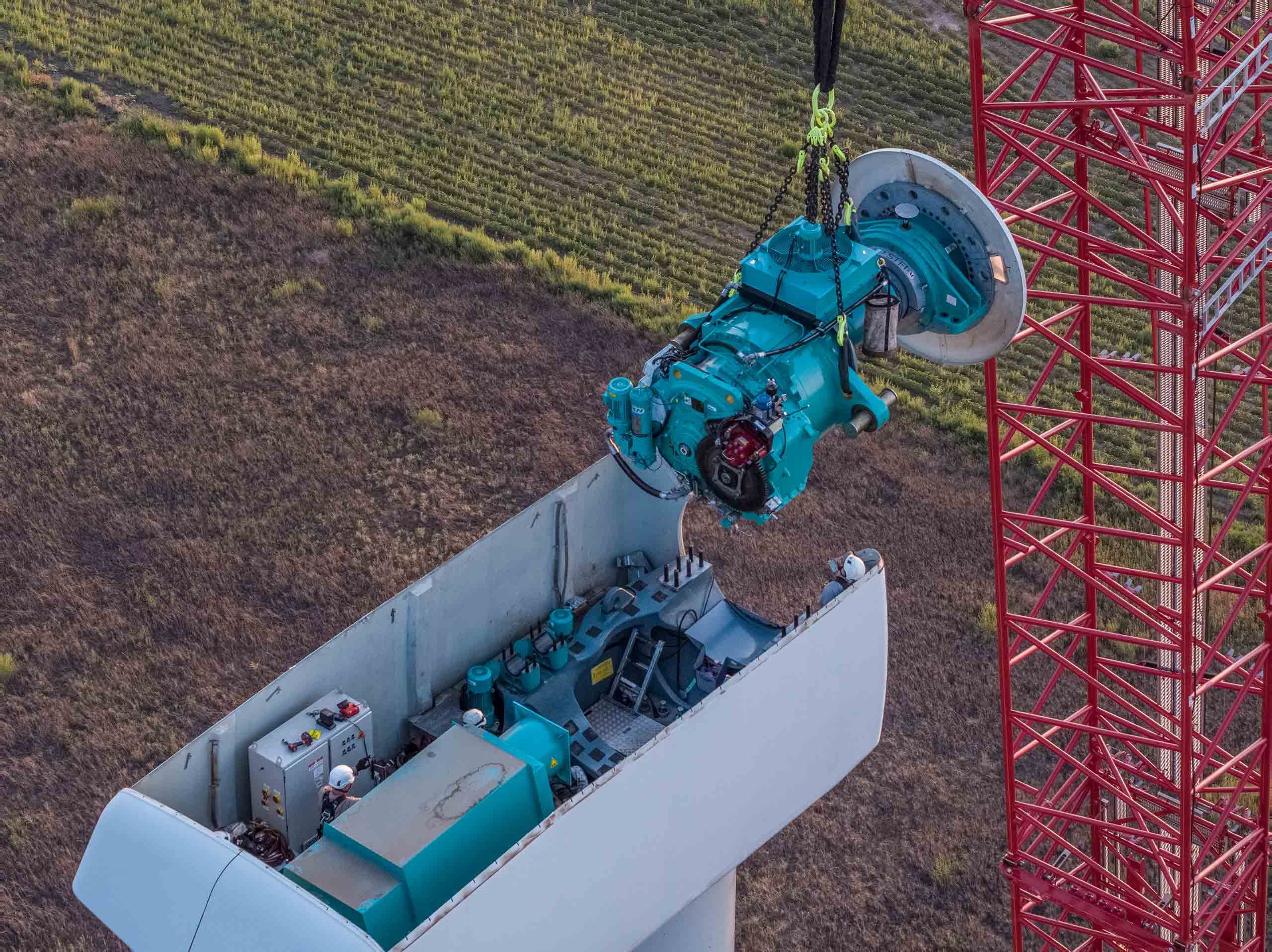 Aerial photo of a wind turbine technician replacing a turbine generator, emphasizing technical expertise in renewable energy maintenance. Drone Aerial of Wind Turbine Technician - Generator Replacement