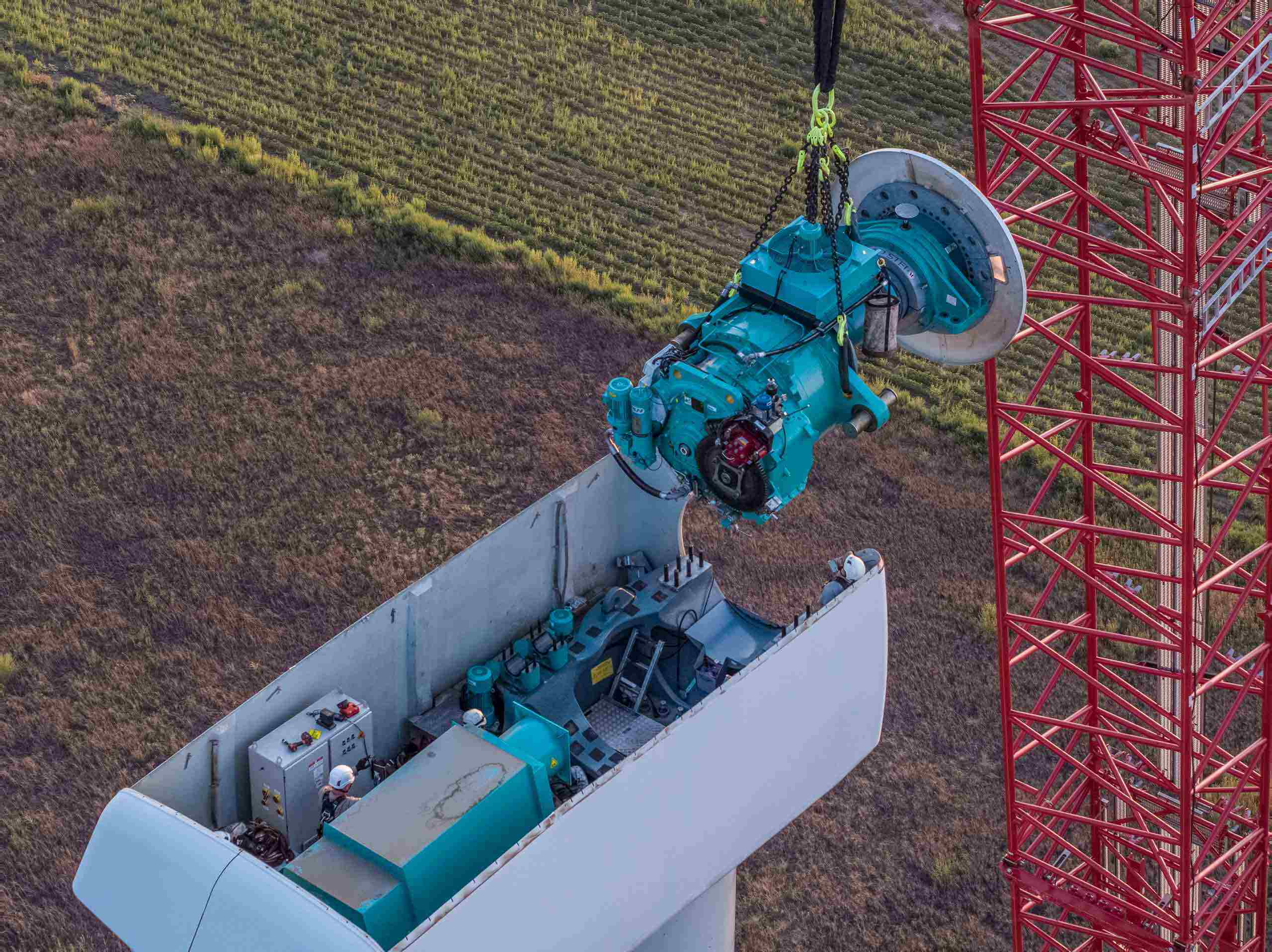 Aerial photo of a wind turbine technician replacing a turbine generator, emphasizing technical expertise in renewable energy maintenance. Drone Aerial of Wind Turbine Technician - Generator Replacement