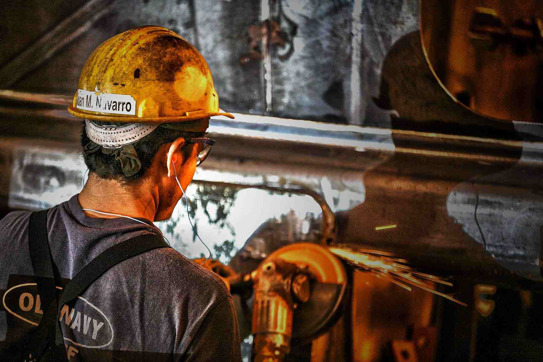 Factory Worker Grinds Metal for Rail Car Production