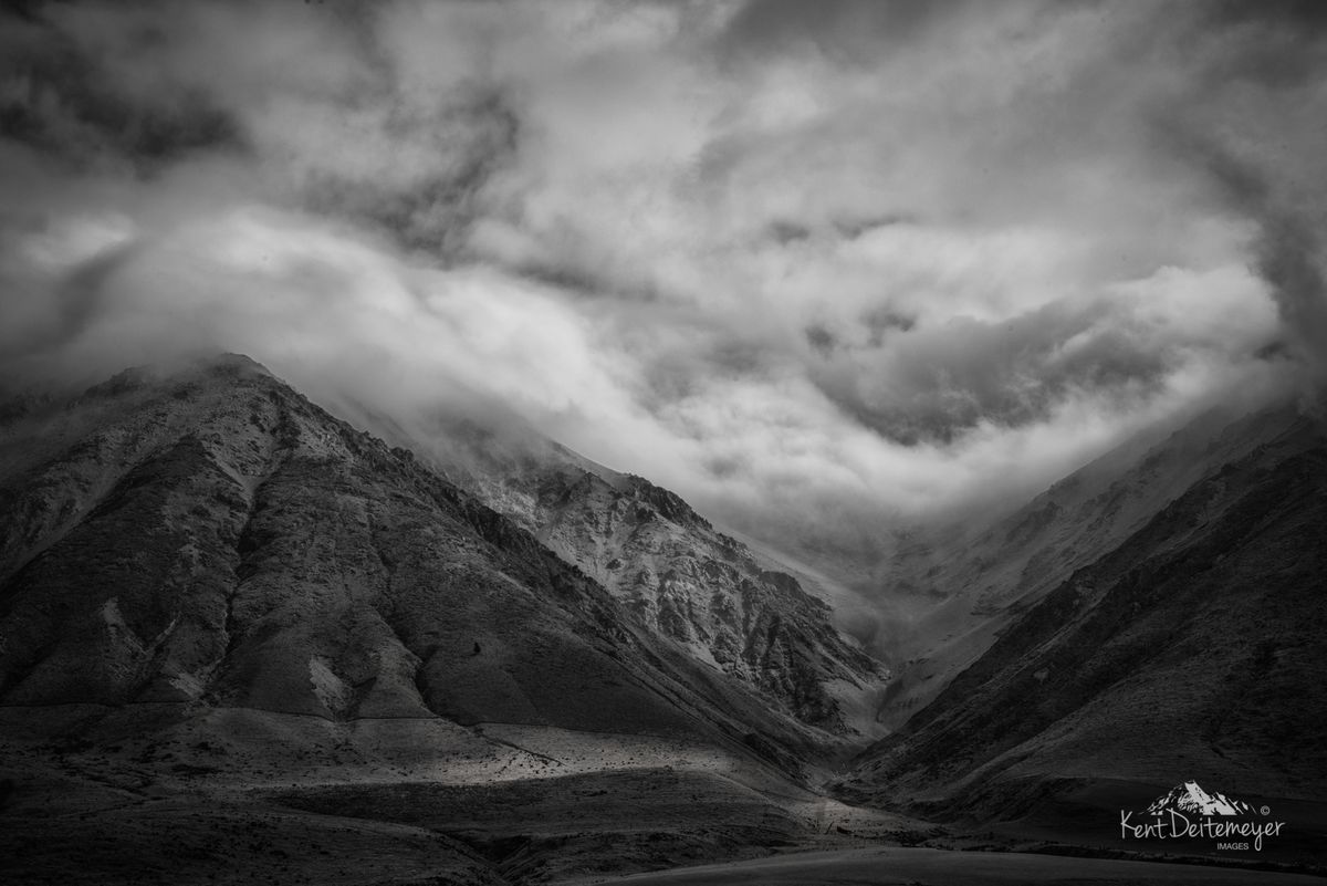 In New Zealand we say there are four seasons in one day. The weather moves in and out in a matter of minutes sometimes.  On the road to Glenariffe Station, the mountains guard the valley as the ramparts to a castle. This is near the beginning of the road to Glenariffe with the weather boiling over the northern flank of Mt Hutt giving the photographer the serendipity of light and an atmospheric circus of clouds. Mt Hutt and the Rakaia River Valley