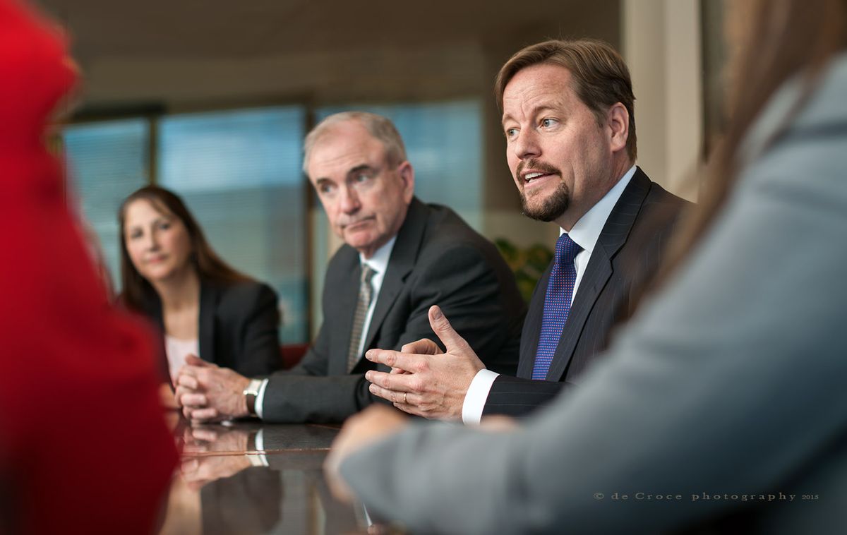 EPS Settlements Group president Brad Cat speaks while CEO, Joe Costello and others listen in this editorial business photo by Denver photographers corporate. Business Meeting - EPS