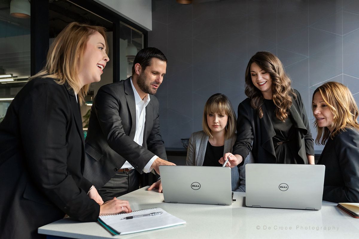 Business meeting photography Dell advertisement photography commercial featuring office workers cajoling around Dell laptop computers. Dell Computer Adveritsment Photography