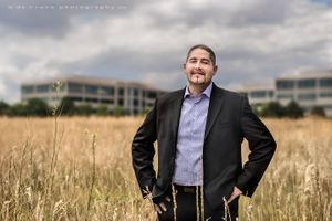 A tall grass field near Denver business office provided interesting set for this Hispanic business leader portrait photography Portrait Executive Photography In Field Near Office