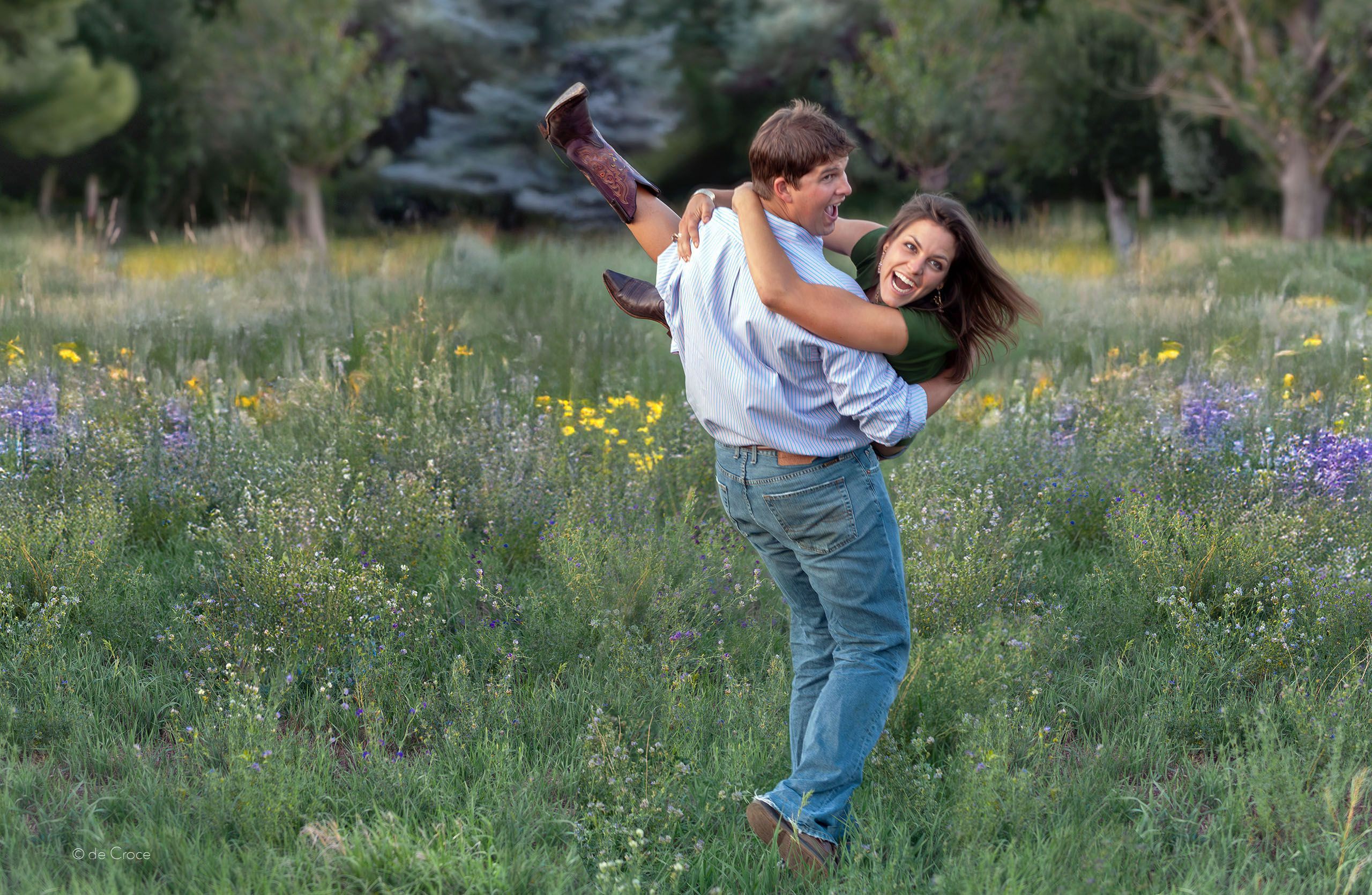 A playful young couple is depicted in this advertisement for western a boot company in Colorado. In the photograph, the man carries his lady across a field as they laugh while looking off camera to their left side. This image was selected because the wester cowboy boots are cleverly catch the eye of a viewer. Western Boot-Advertising Photography