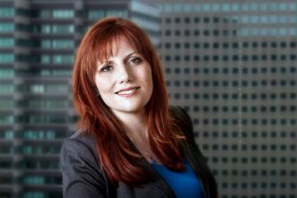Portrait of business woman in red hair with building windows background. Business Denver Head shot Photographers