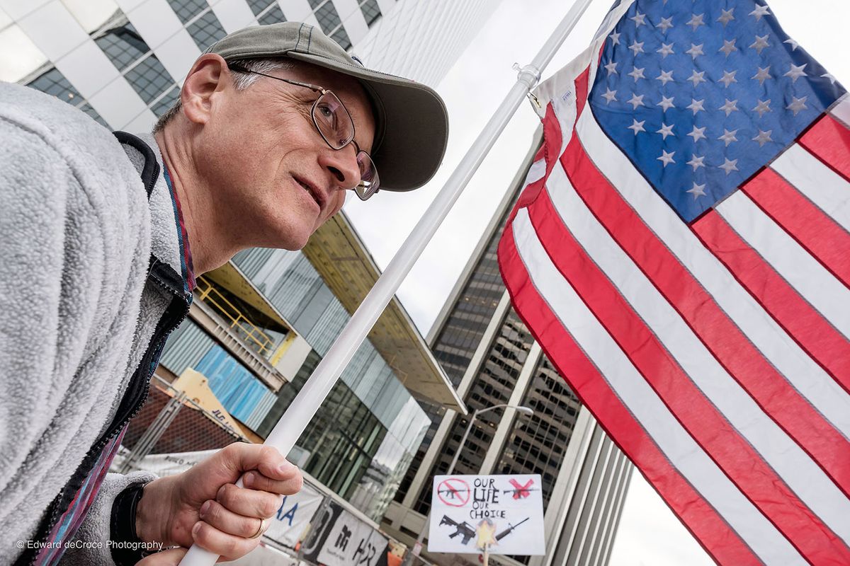 Man with American flag protests for gun control after kids die in school shooting violence Photojournalism Denver
