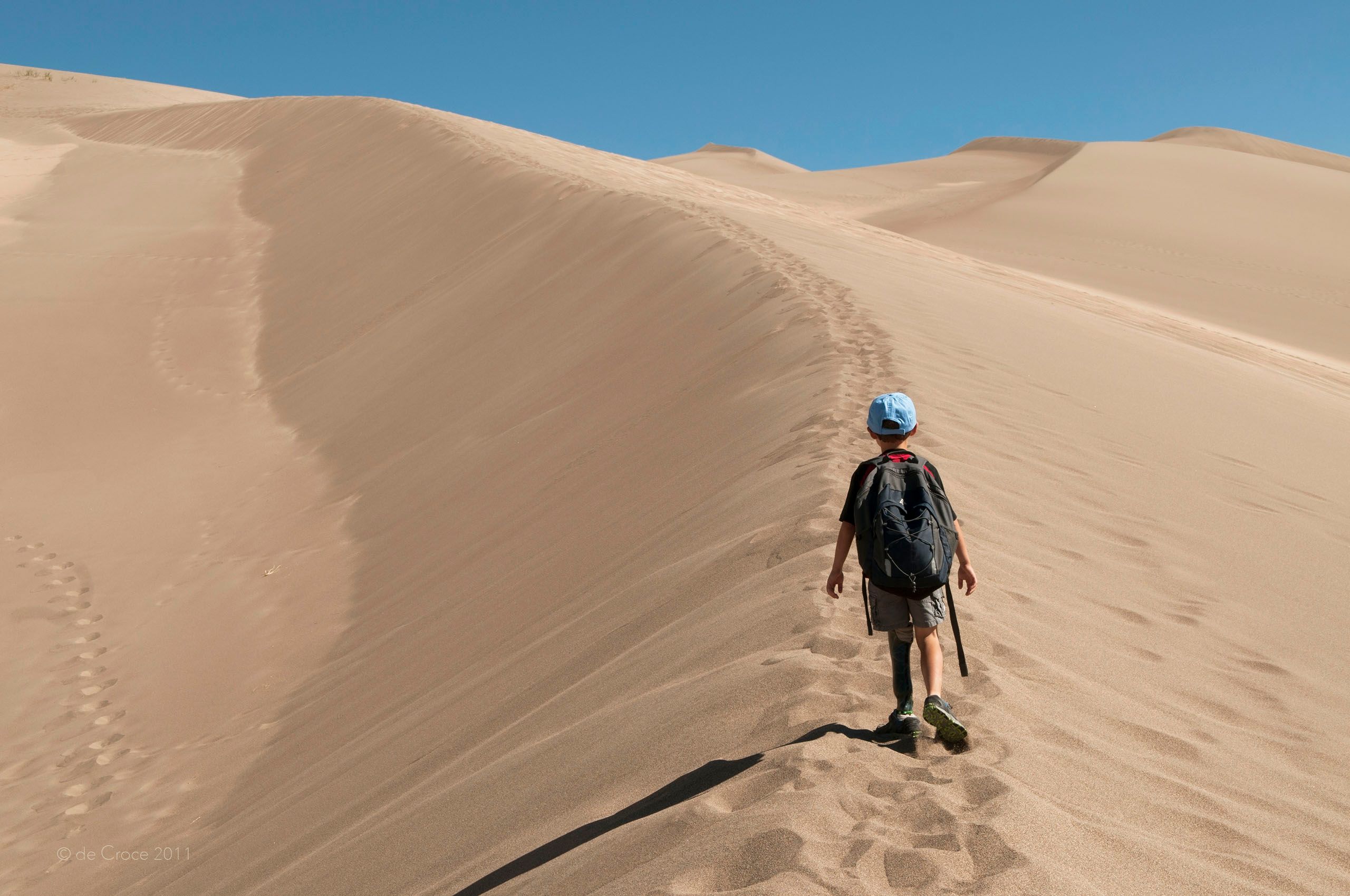 Boy with prosthetic leg hikes in sand dunes Colorado Dune Hike - Lifestyle Photography