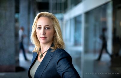 A Denver business headshot –– I love this action portrait of attorney Julie Walker of Kelly & Walker LLC. As we worked in the outdoor lobby of a nearby bank, two passerbys in the background, hit the same stride at the same moment. Make-up by Suzanne Blons. Attorney Portrait -Julie Walker