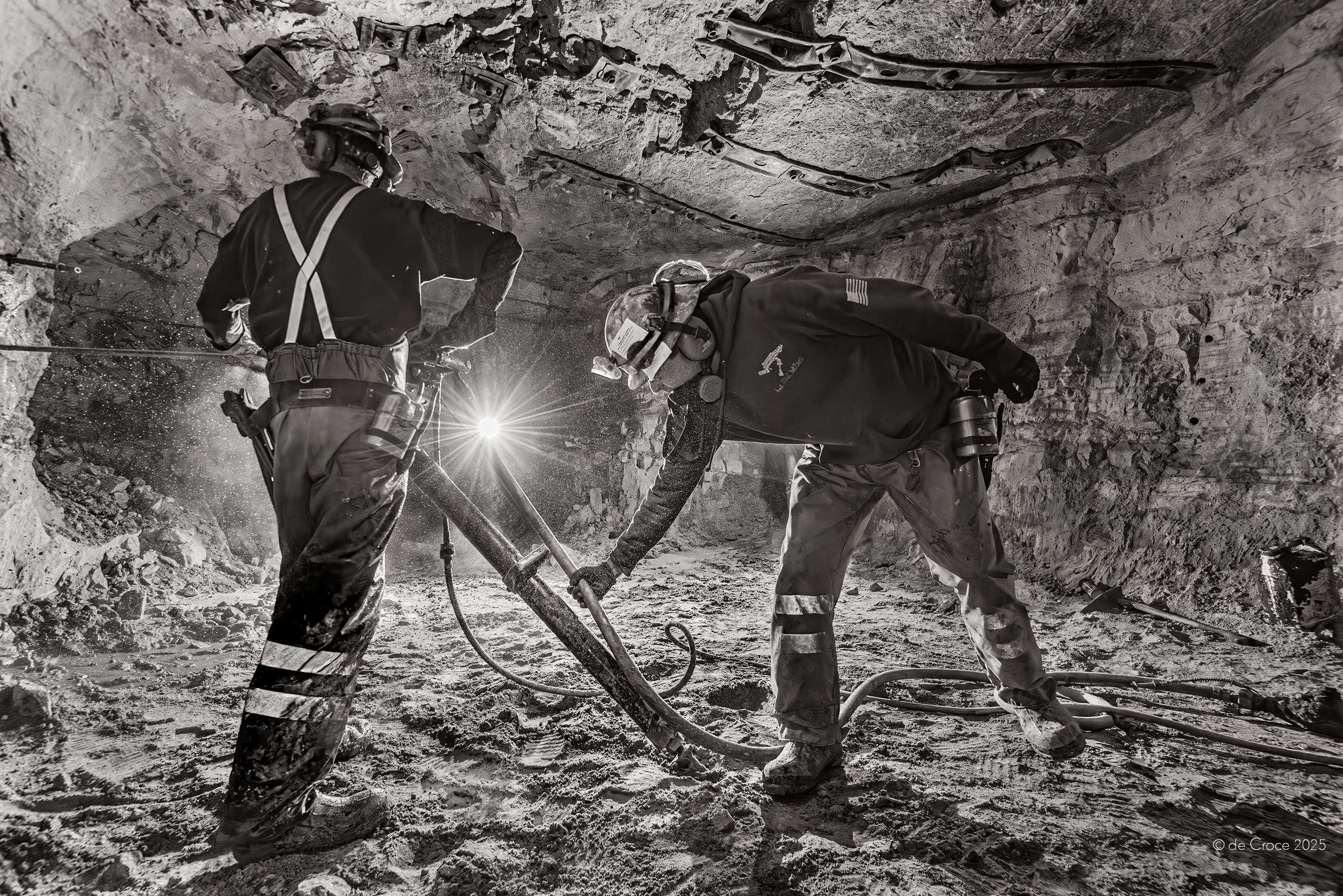 Black and white industrial photography depicts underground uranium miners in dark tunnel for Energy Fuels in Arizona. Photographed by American Industrial photographer, Edward DeCroce Underground Uranium Mine Workers. Photographed By American Industrial Photographer, Edward DeCroce