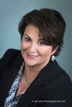 This executive portrait headshot looks like a studio portrait. But Denver business photographers created the business portrait on location in Denver office cubicle. make-up by Kalyja Rain Executive Photography Portrait On Blue