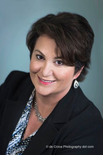 This executive portrait headshot looks like a studio portrait. But Denver business photographers created the business portrait on location in Denver office cubicle. make-up by Kalyja Rain Executive Photography Portrait On Blue