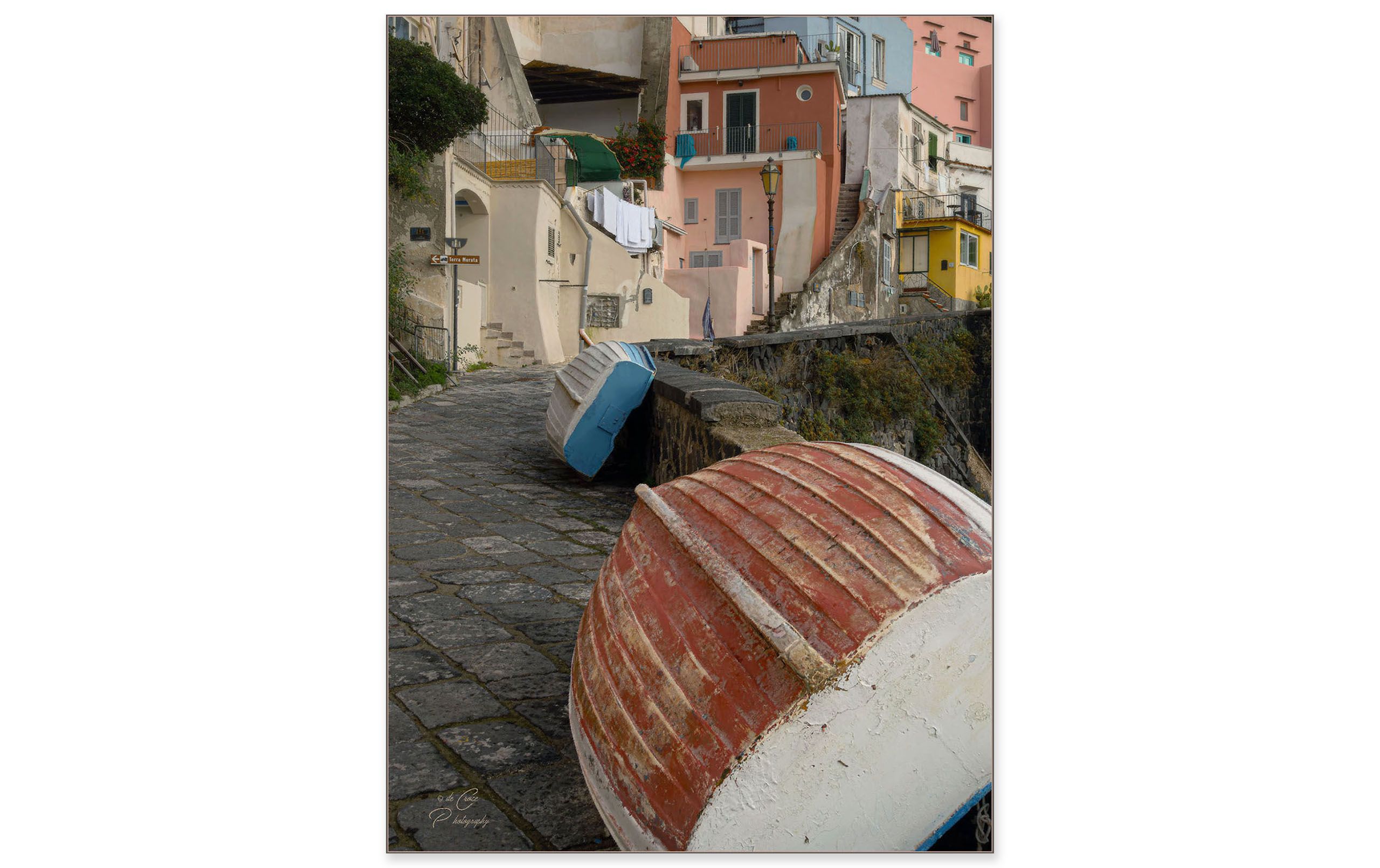 In Procida Italy travel photography, two boats lean against ancient wall. Italian Via And Boats