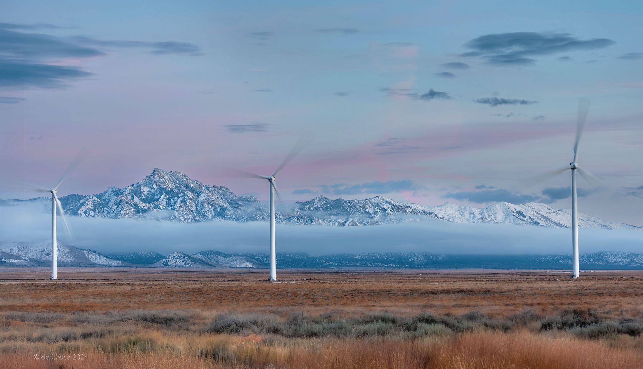Commercial photographer, Denver based, travels for advertising photoshoot in Utah to capture industrial energy images. This stunning photography depicts wind turbines in high valley set against majestic granite peaks after freshly fallen snow. Operated by Longroad Energy Energy and maintained by Deutsche Windtechnik USA, the wind farm is located in southwestern Utah near Milford. Commercial Photography - Wind Energy Landscape, Utah
