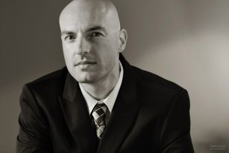A black and white business portrait headshot accentuates contemplative mood during corporate portrait session. Contemplative Business Headshot Portrait
