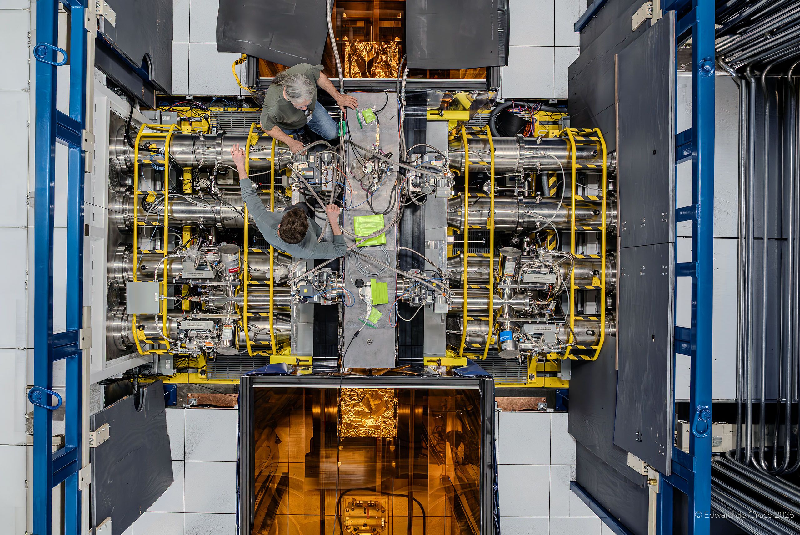 American industrial photographer crafts aerial drone imagery for Xcimer Energy in Denver Colorado. This image depicts two laser scientists as they complete research experiments. Laser Research For Nuclear Fusion Energy At Xcimer Energy In Denver Colorado - Photographed By American Industrial Photographer, Edward DeCroce