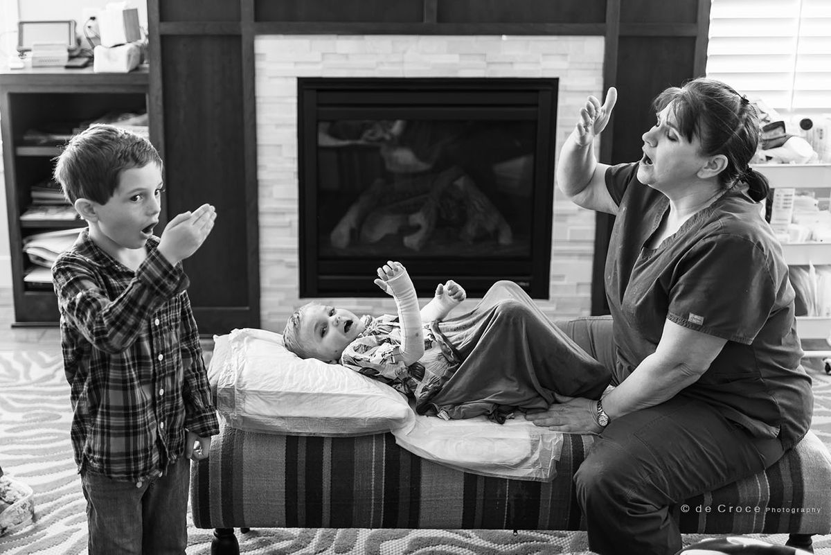 Medical photojournalism in home with nurse and brother of boy with EB Skin Disease Family Photography Editorial