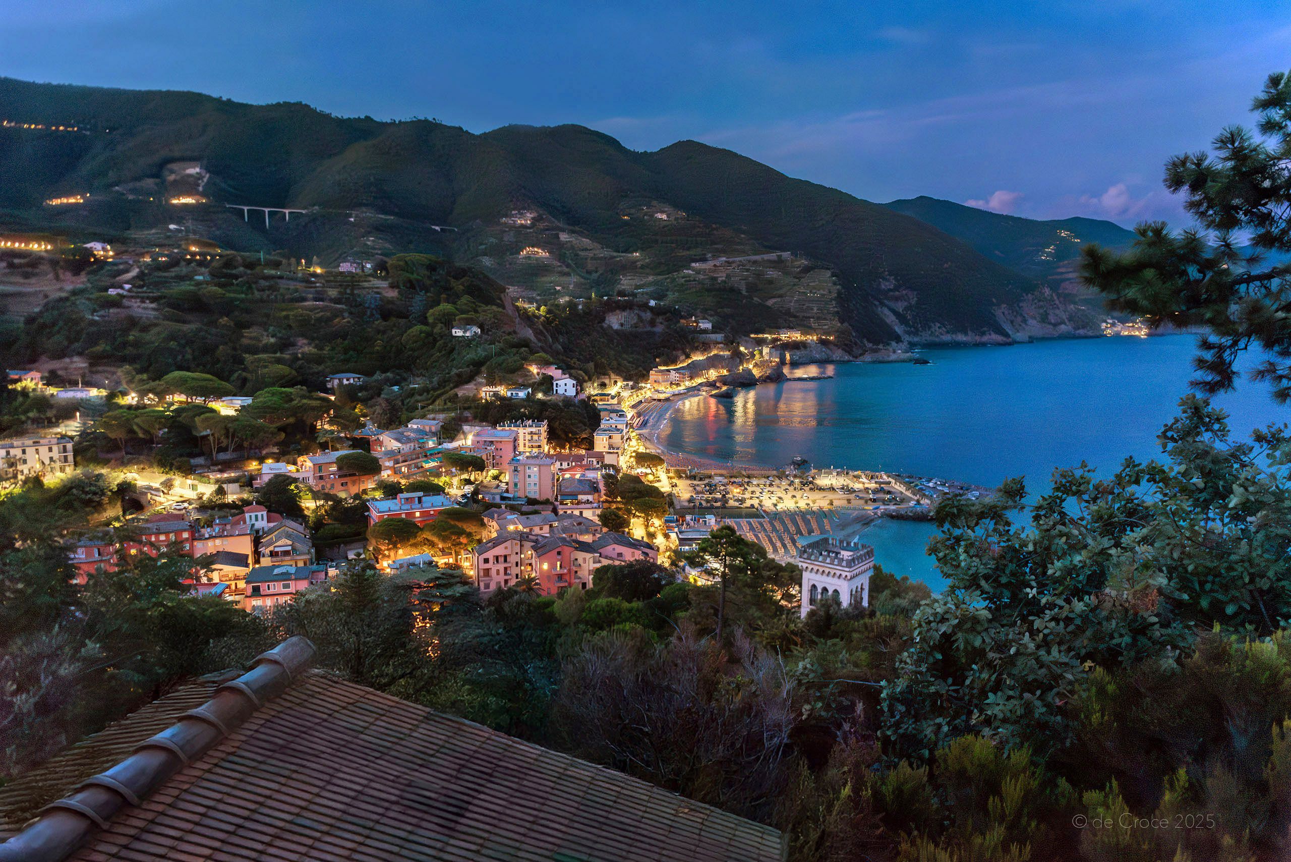 This Cinque Terre view features Monterosso al Mare and night with the smaller village of Venazza in the distance. The travel photographer cut a path with machete at night on steep slope to capture this iconic travel scene. Travel Photography - Monterosso Al Mare & Vernazza - Cinque Terre Italy