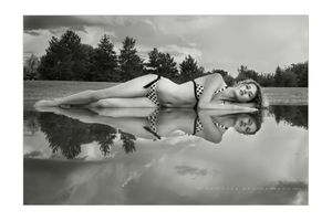 Denver model Maddie Kerr in fine-art photography after rainstorm leaves puddle in park. Denver Model In Pond
