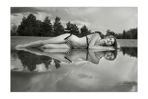 Denver model Maddie Kerr in fine-art photography after rainstorm leaves puddle in park. Denver Model In Pond