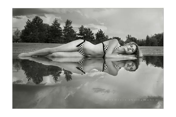 Denver model Maddie Kerr in fine-art photography after rainstorm leaves puddle in park. Denver Model In Pond