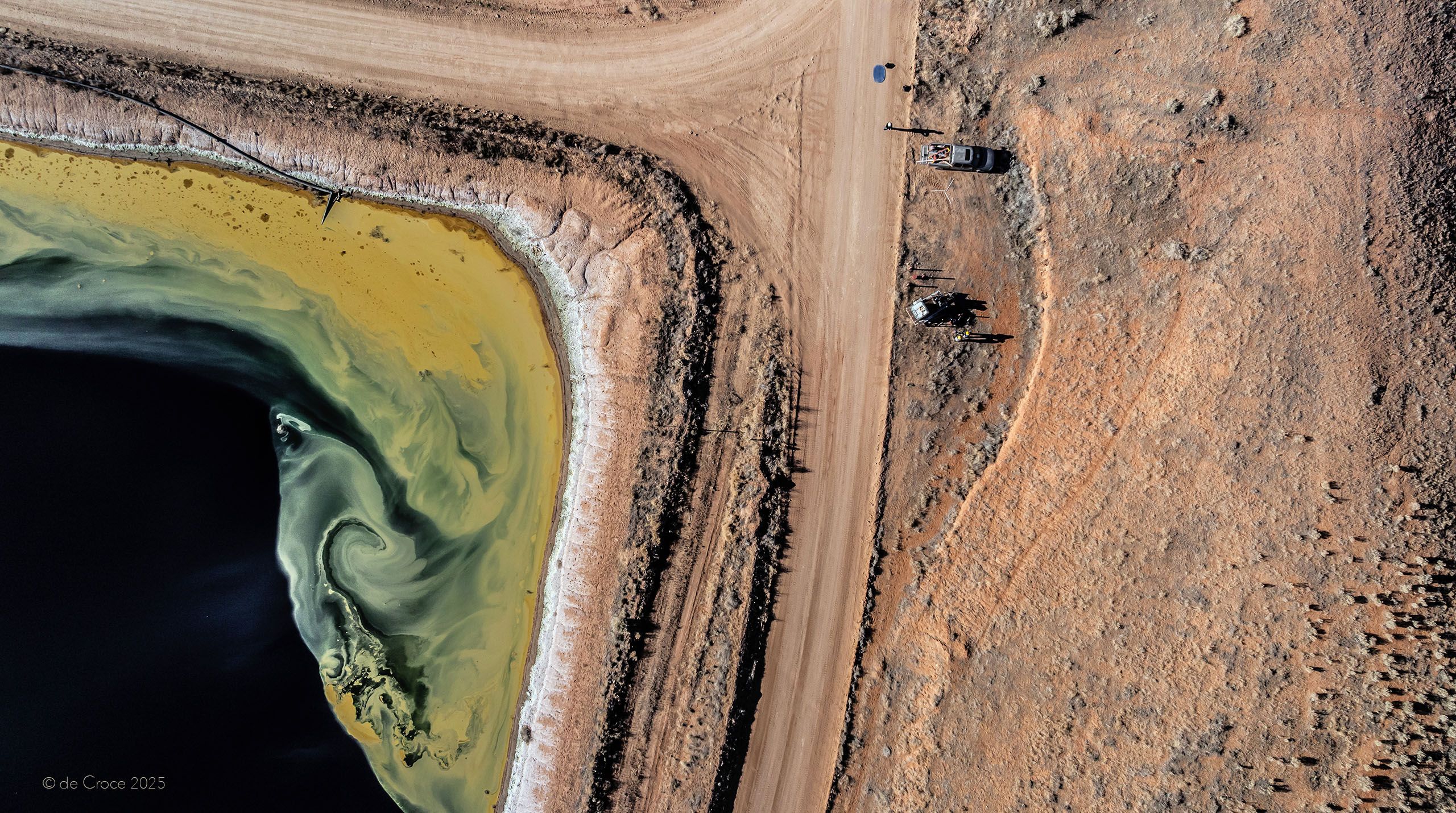 Commercial photographers travel to Utah for aerial industrial photoshoot. This image, shot from 300 feet above land surface depicts tailings pond uranium and service road. Commercial Aerial Photography - Tailings Pond - Utah