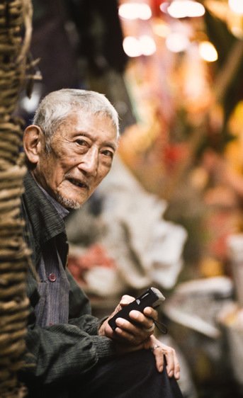 Elderly Gentleman listening to a transistor radio in Hong Kong