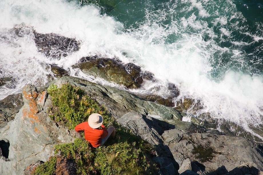 Man sitting the edge of the Atlantic Ocean.
