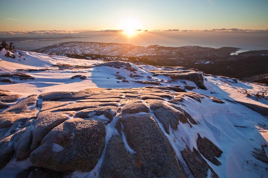 Sunrise on the summit of Cadillac Mountain in Acadia National Park, after a winter storm.