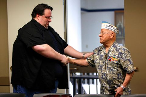 Michael Mickey Ganitch, 92, shakes hands with a local man who gave him a sextant after Ganitch's original sextant, which he used during World War II , was stolen. pearlharbor.jpg