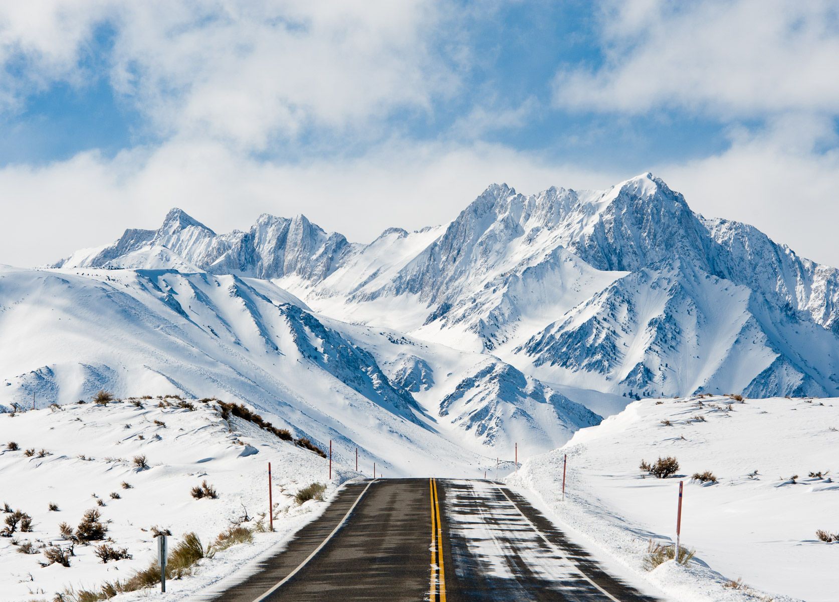 Road Leading Toward Snow Covered Mountains