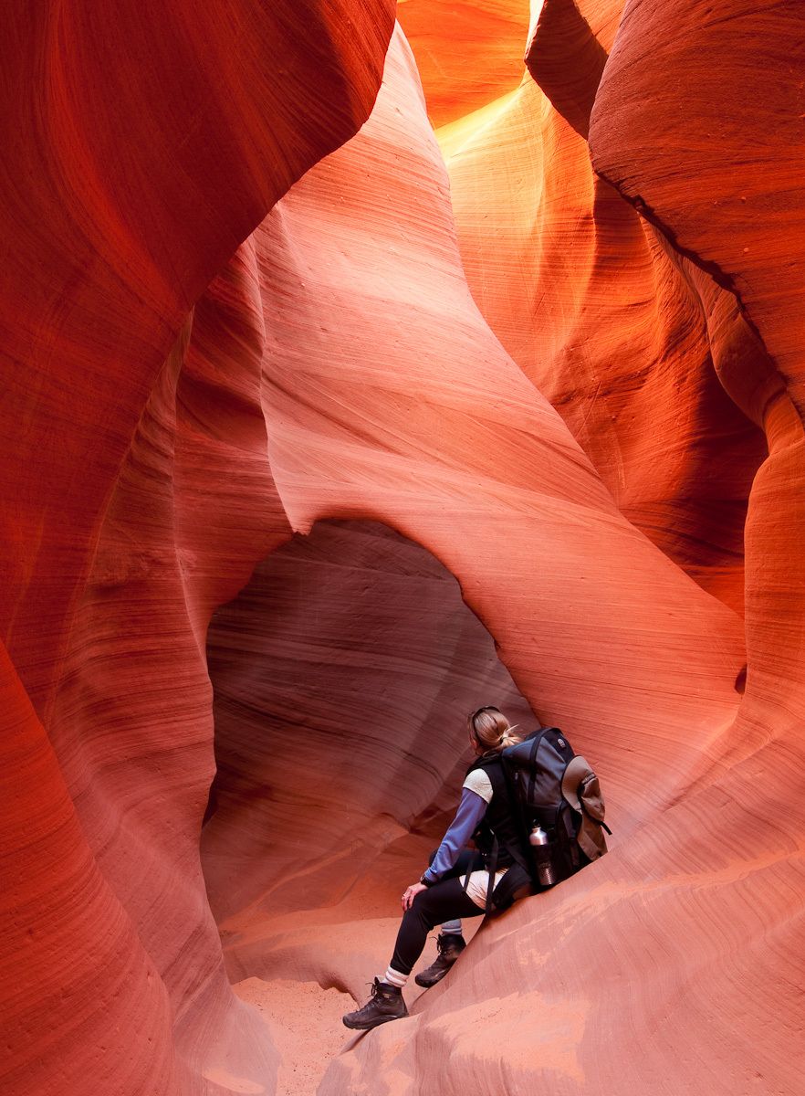 Woman Takes a Break From Hiking while Looking up at Slot Canyons