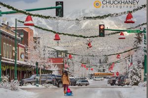 A mother takes infant for a sled ride down Central Avenure in Whitefish, Montana, USA Whitefish Fresh Snow