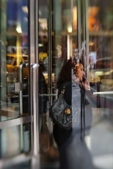 A 57th Street shopper caught in refracted light and reflections. 2009 for Saul Leiter, New York City
