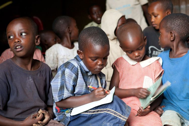 Children squeeze onto a bench to attend an Empowering Life-long Skills Education lesson. This ELSE project provides one morning of lessons a week to children who otherwise would have no access to education at all. Masindi District. 1uganda_education_10.jpg