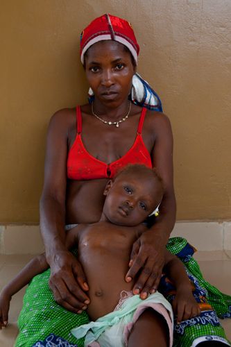 Abdul, 1 year 10 months, with his mother Adama. Abdul arrived at the hospital 24hrs earlier so severely dehydrated the doctors did not think he would survive. The family had initially sought advice from a herbal doctor but after ten days of their child vomitting and not drinking had bought Abdul to Makeni Hospital. Health care for the under fives is free is Sierra Leone but due to corruption medicine is rarely available and parents must pay high prices on the black market. Sierra Leone. 1sierra_leone_child_health_17.jpg