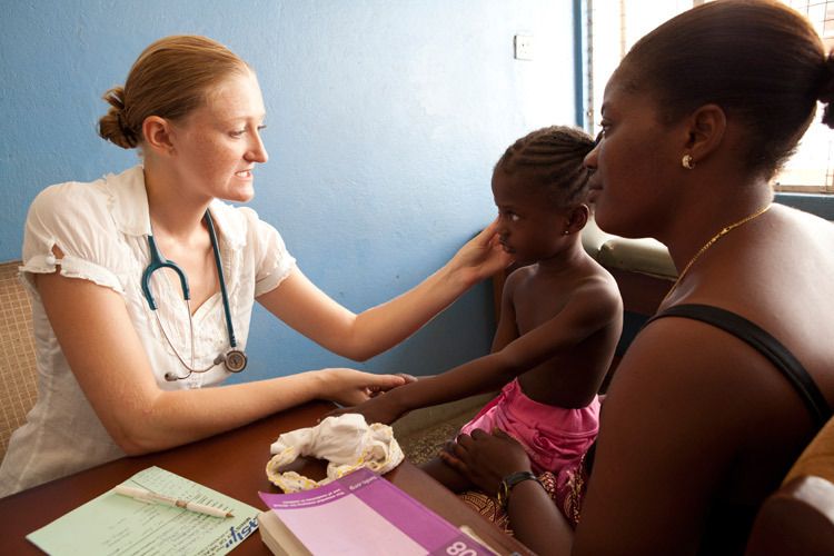Shona Johnston, Paediatrician and VSO volunteer examining 4 yr old Mariasu Z. Jabbie at the outpatients clinic of Ola During Childrens Hospital, Freetown, Sierra Leone. Shona discusses Mariasu's health with her mother Mariana Kamara, 22yrs. 1sierra_leone_health_freetown.jpg