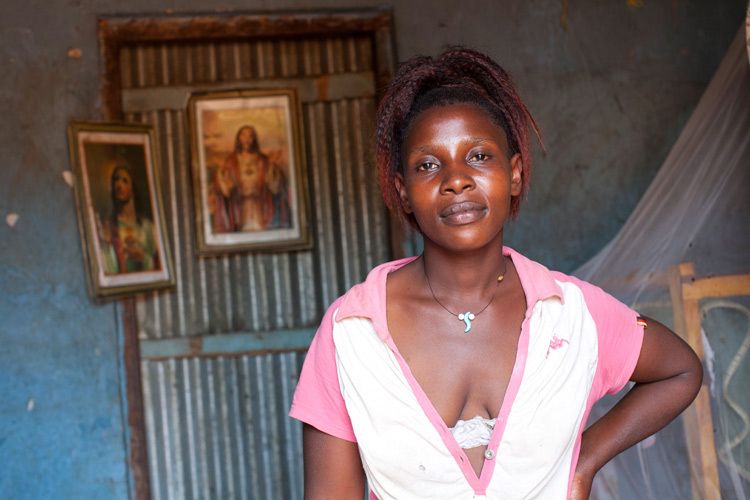 Annet 24 yrs, Commercial sex worker, in the one room  apartment she shares with her five children. Bwaise slum, Kampala, Uganda. 1uganda_sex_worker_24.jpg