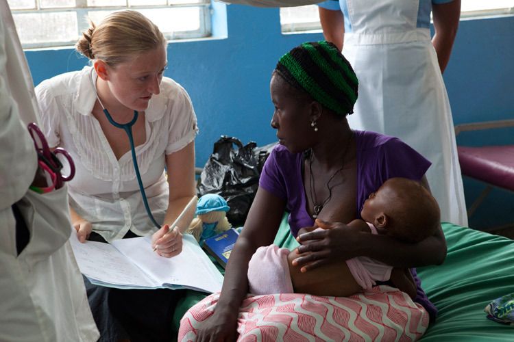 Shona Johnston VSO Volunteer & Paediatrician working in the Therapeutic Feeding Centre at Ola During Childrens Hospital, Freetown. Shona examines Kadiatu, a malnourished 15 month old baby girl and discusses the childs health with her mother Hawa Kamara. Sierra Leone. 1sierra_leone_malnutrition_baby.jpg