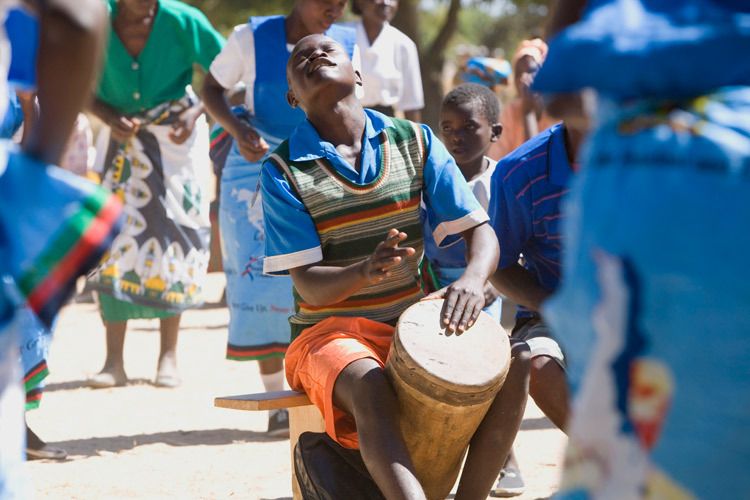 Dongo,15 years old plays drums for the Bulala Youth group at an event to highlight the dangers of HIV/AIDS. Dongo cares for his 11 year old sister and 15 year old brother. His mother is dead and his father is in jail for stealing cattle. It is only with the support the Bulala youth group has given him that he is still able to attend school. Bulala, Malawi. 1malawi_hiv_child_orphan.jpg