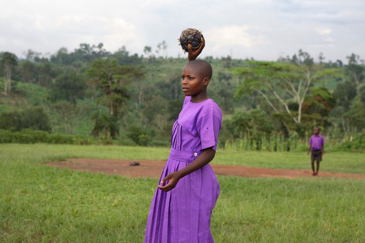 Justine Nyirantungane 15 years old with handmade dodgeball,  Kitemba primary school. Girls often miss weeks at a time of their education due to parents taking them out of school to help with farming. Boys' education is prioritised and their studies usually remain uninterrupted . This can result in teenage females repeatedly trying to pass end of year exams in order to progress to secondary school. Mubende, Uganda for ActionAid. 1play_uganda_child.jpg