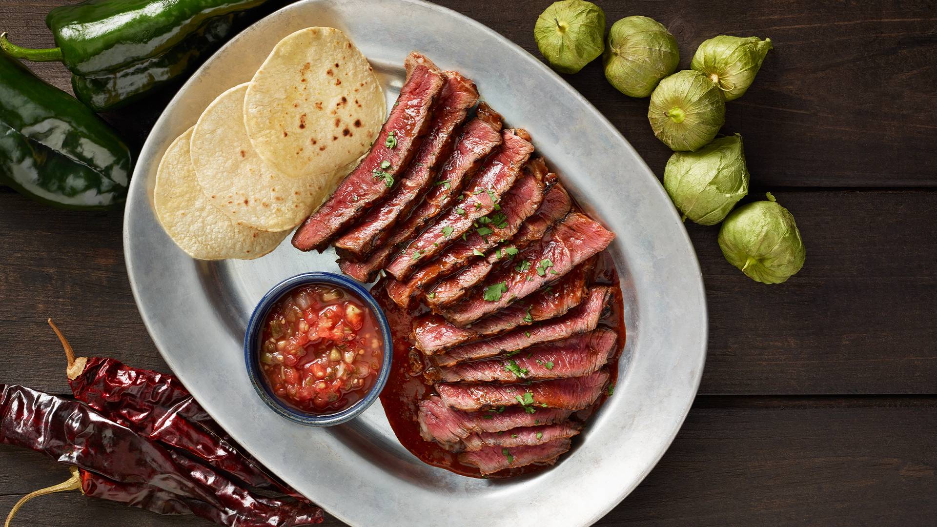 Sliced steak for tacos with hot peppers and tamotillos