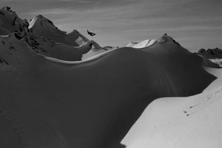Mikkel Bang. Lech, Austria finds an amazing powder backcountry jump and sends it super high in the air above a landing of powder snow Snowboarder catches massive air in Austria
