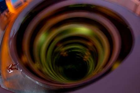 Skateboarder on the edge of spiral parking garage looking down into the vortex of color. Skateboarder slides on top of a parking garage