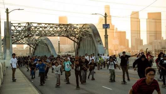 Skaters. Los Angeles, CA crossing 6th street bridge during sunset A massive group of skateboarders skates across a bridge in Los Angeles