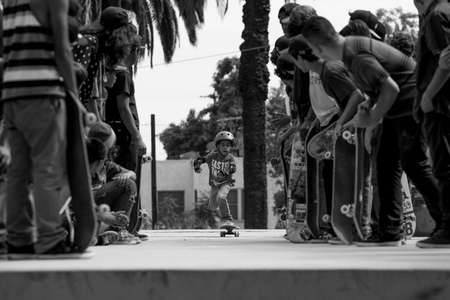 Skater. Los Angeles, CA A young skateboarder approaches a large set of stairs with a helmet on Young skateboarder pushes into large stair set