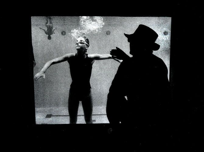 Coach instruts his swimmer through an underwater window.