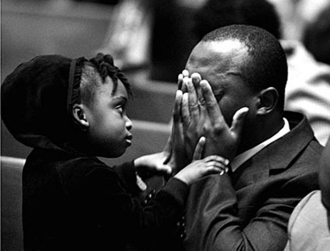 Daughter comforts her father during a vigil for Haitian's lost during a hurricane.