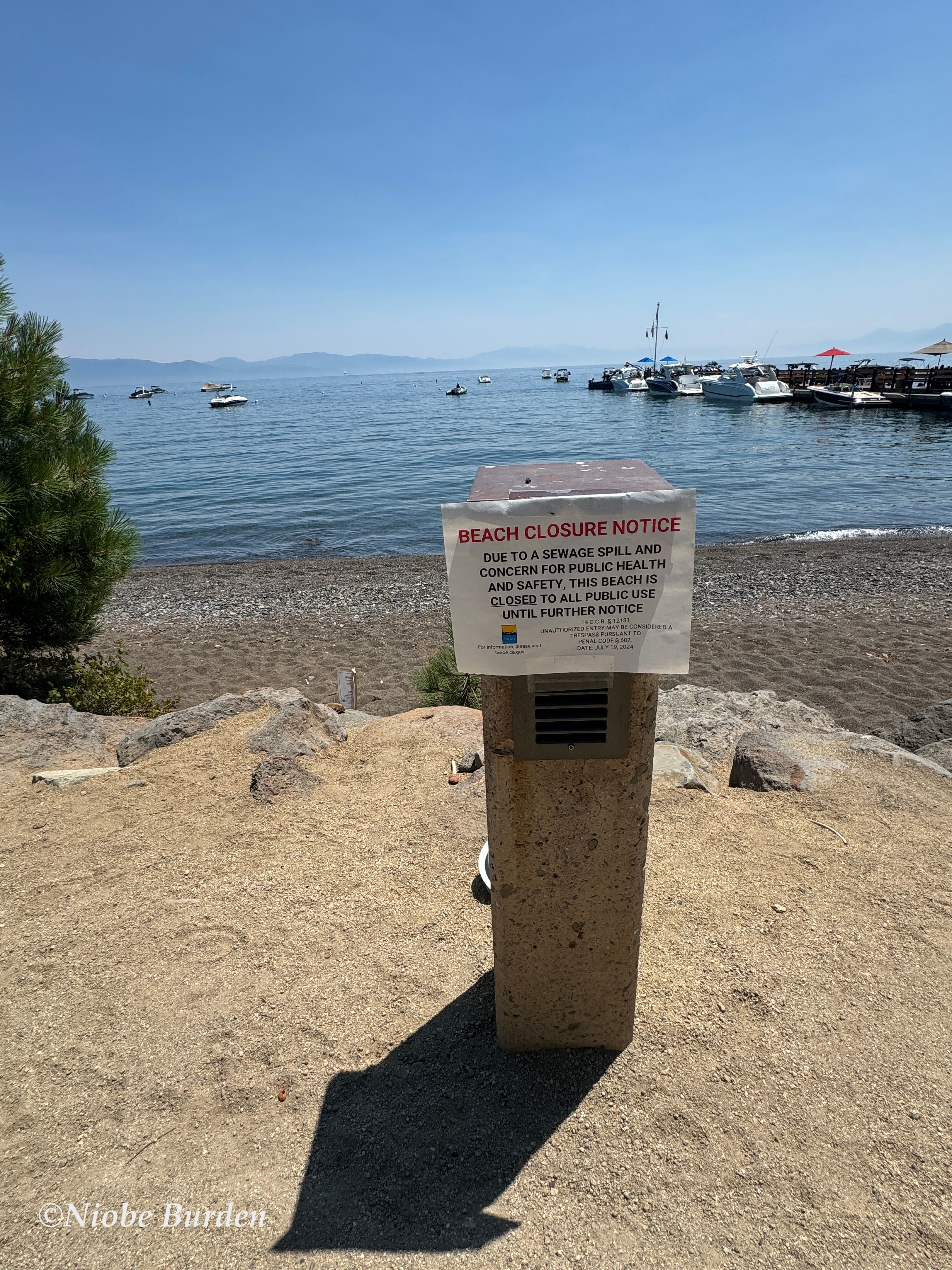 Signage indicating beach is closed due to sewage spill