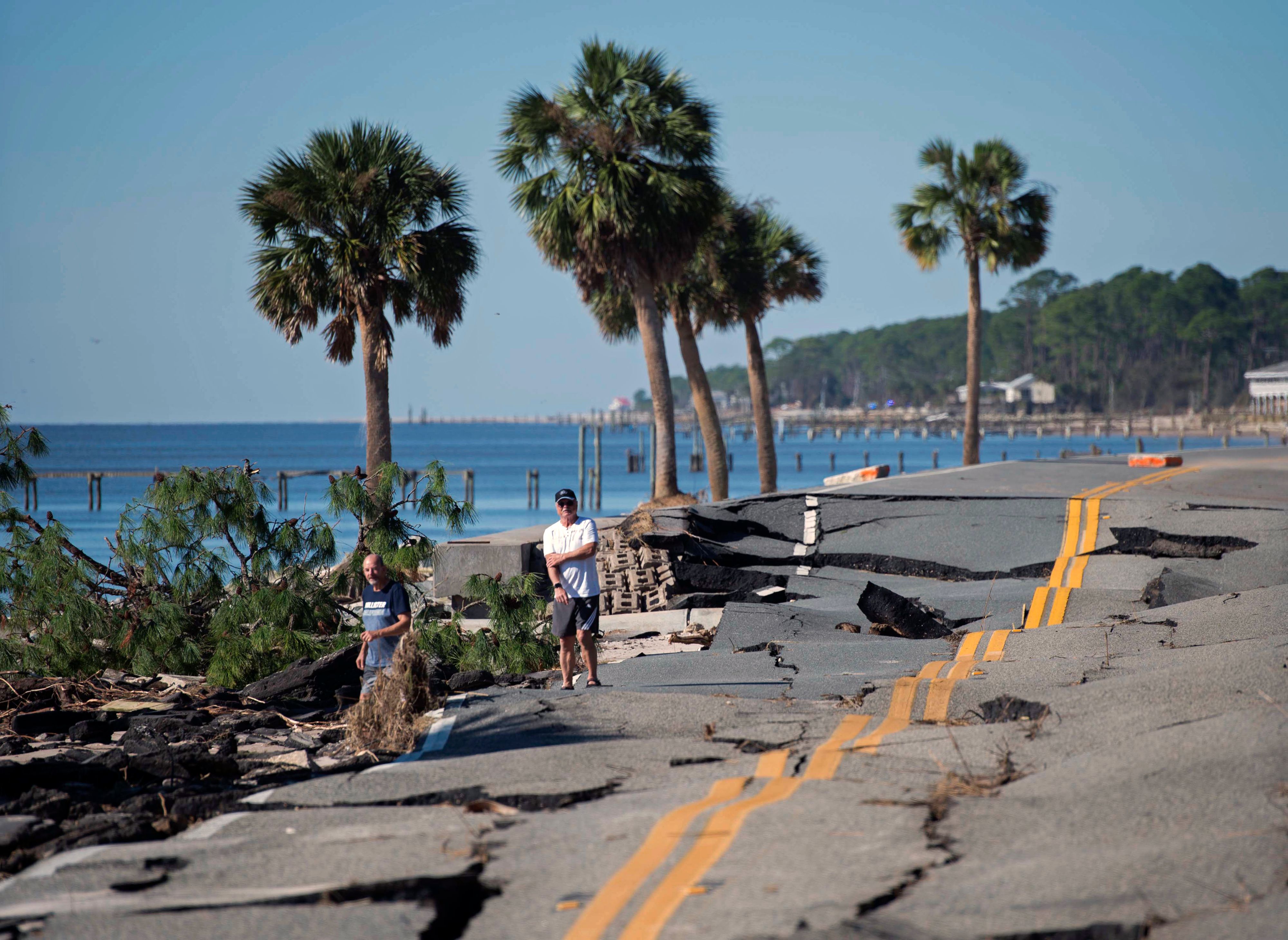 Two men look at a road destroyed during Hurricane Michael near Eastpoint, Florida on October 12, 2018. 19Z6MD.jpg