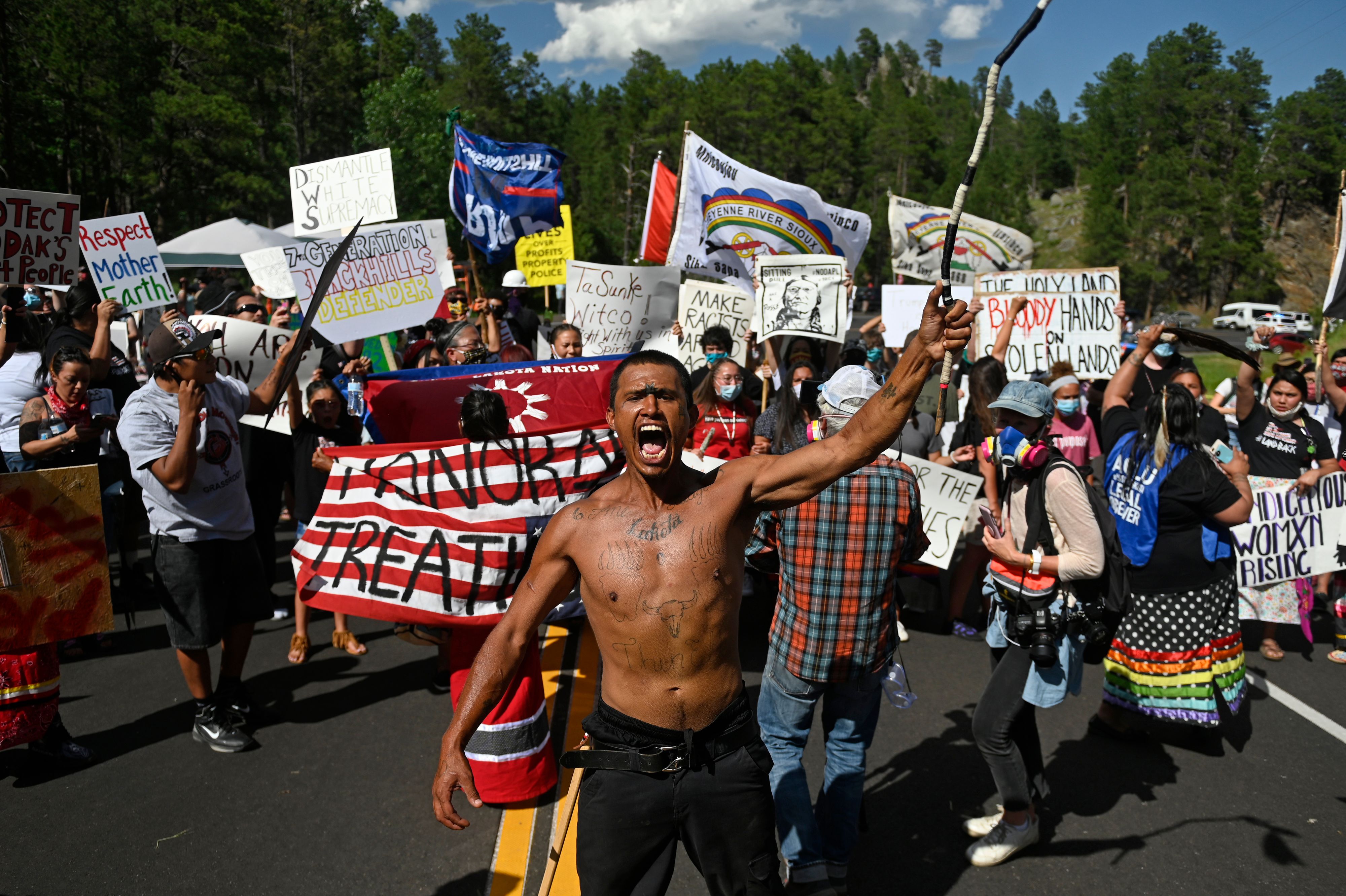 Activists and members of different tribes from the region block the road to Mount Rushmore National Monument as they protest in Keystone, South Dakota on July 3, 2020, during a demonstration around the Mount Rushmore National Monument and the visit of US President Donald Trump. 1UK5VB.jpg